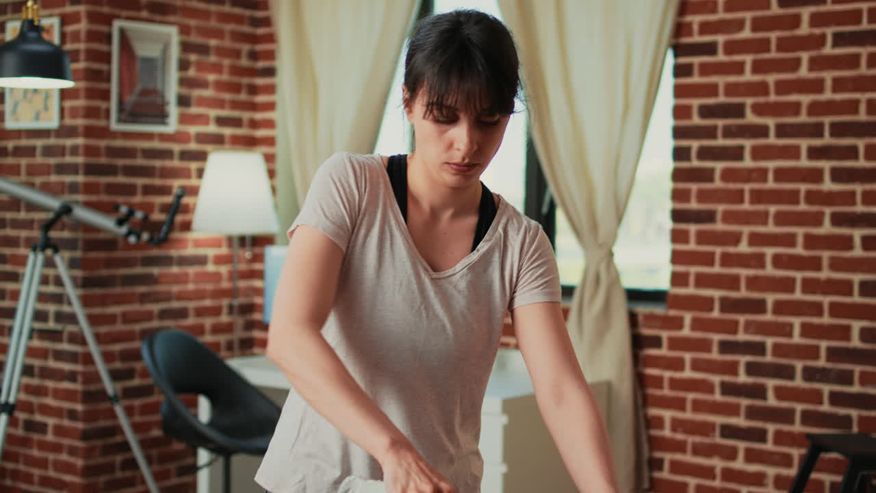 Housewife using iron with steam to smooth out clothes after washing them