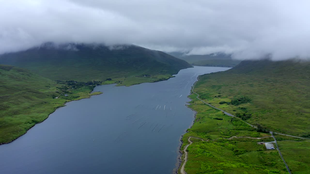 Killary Fjord, Leenane, Connemara, County Galway, July 2021. Drone slowly pushes east towards Leenaun village as low-hanging clouds drift across the mountains