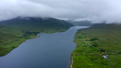 killary fjord, leenane, connemara, county galway, july 2021. drone slowly pushes east towards leenaun village as low-hanging clouds drift across the mountains
