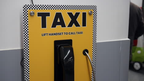 a taxi telephone call phone is on the wall in a supermarket