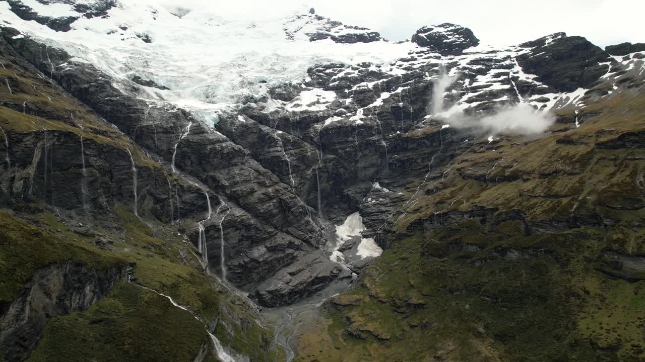 el majestuoso monte earnslaw y el glaciar se derriten en cientos de cascadas hasta el valle - vista de pájaro