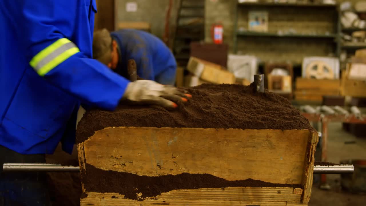 Worker removing soil from molds in foundry workshop 4k