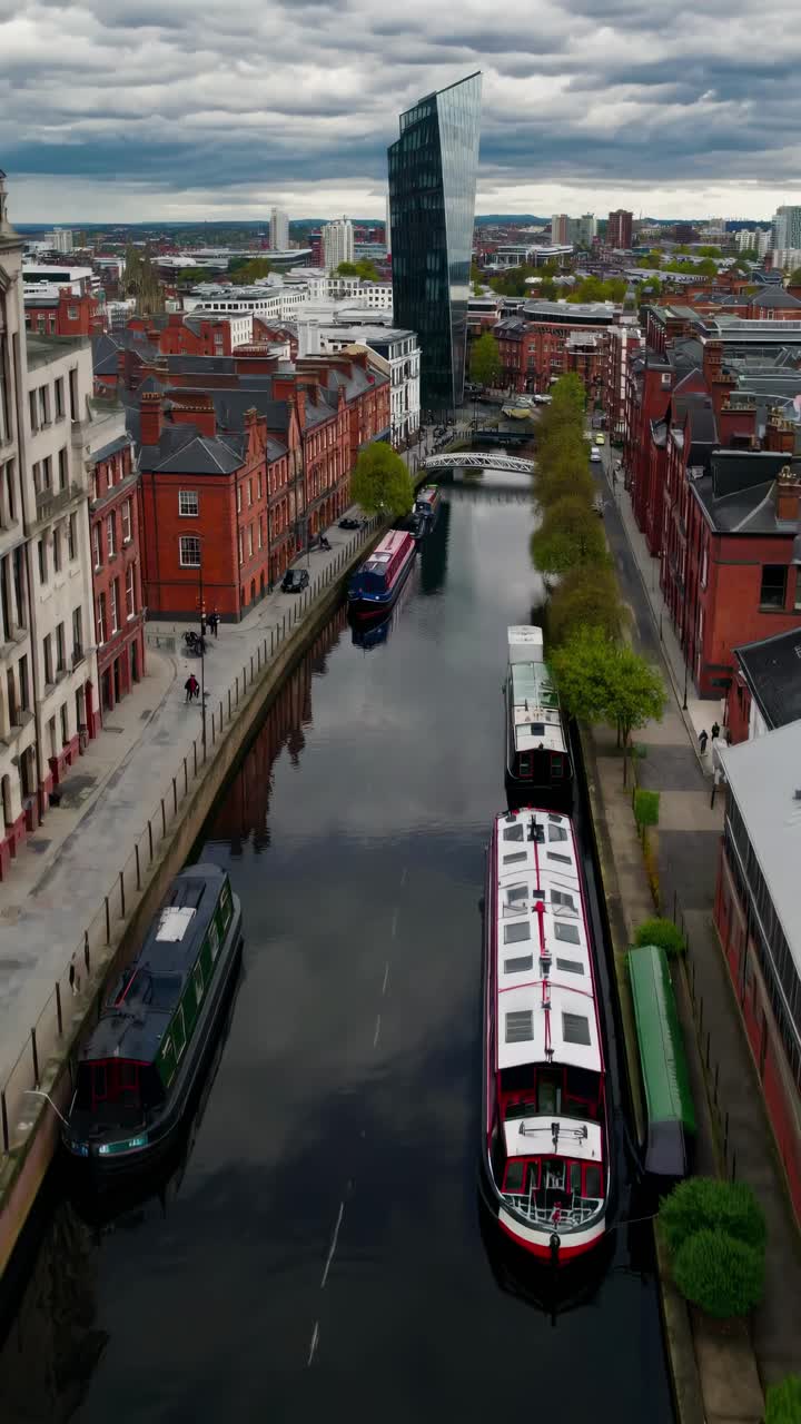 Aerial view of a canal with boats and modern buildings, capturing urban architecture
