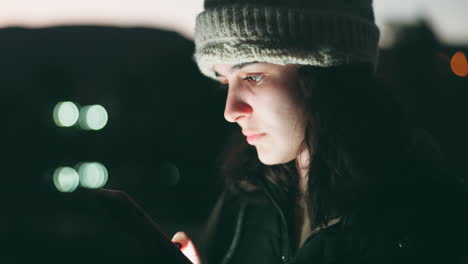 mujer, teléfono y desplazamiento por la noche en la ciudad