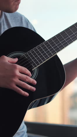 person playing a black acoustic guitar