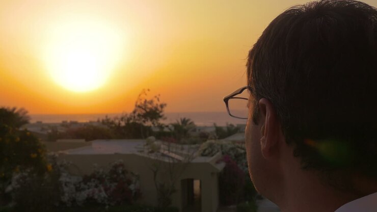 Uomo che indossa gli occhiali per godersi il tramonto