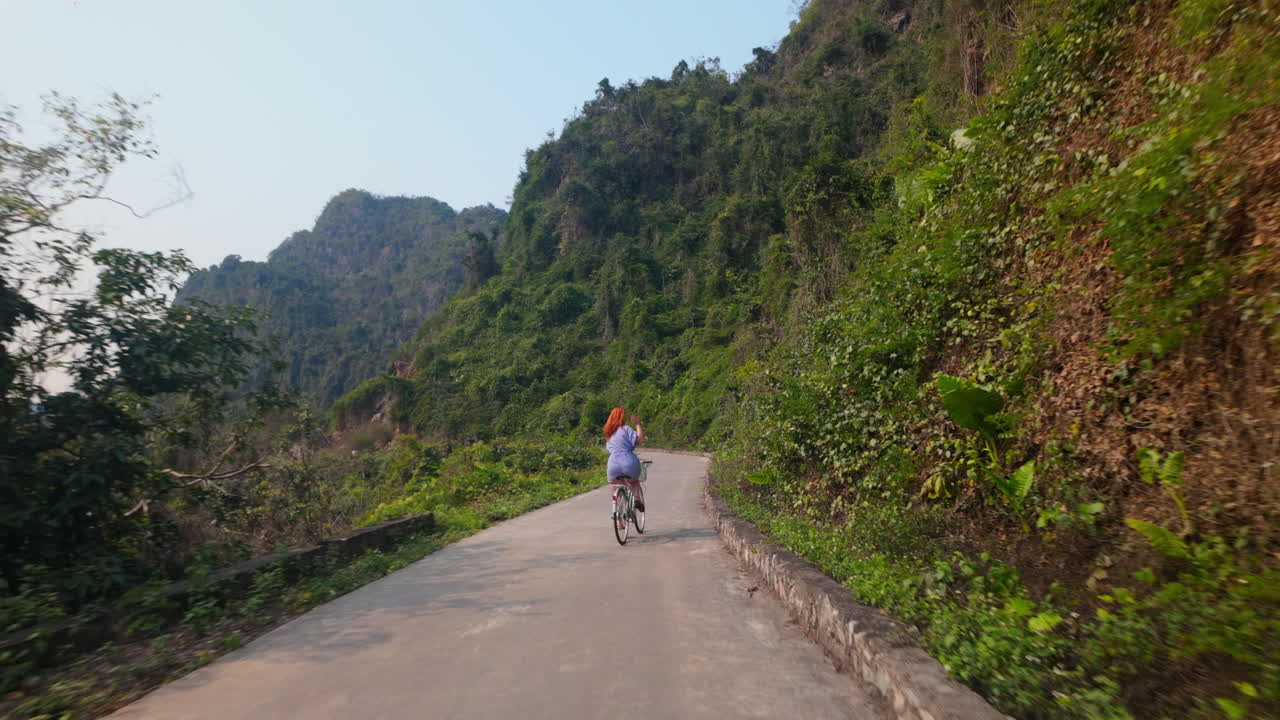 Woman Exploring Viet Hai Village By Cycling Through The Mountains In Cat Ba Island, Vietnam. - following shot