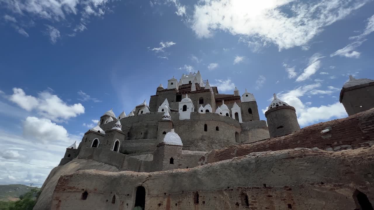 vista de gusanos del gran castillo increíble "zé dos montes" construido por jose a mano con ladrillos de las instrucciones de dios en rio grande do norte, brasil en un cálido día soleado y nublado