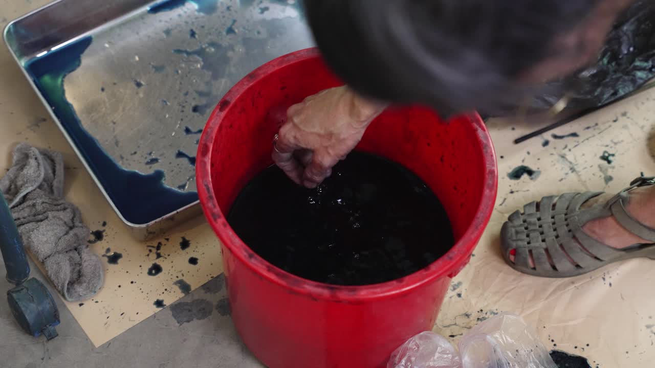 Traditional techniques, liquid bucket, stained hands, colour dye process