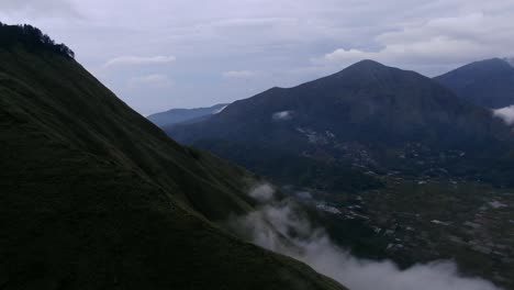 aerial view moving shot, mist on the foot of pergasingan hill, sembalun village in the background