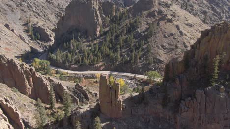 Unique-aerial-view-of-a-rock-climbing-stone-pillar-standing-amidst-the-Rocky-Mountains-on-a-bright-summer-day