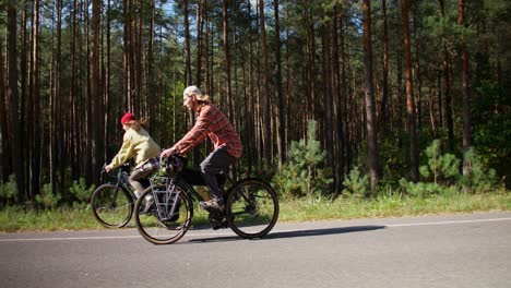 couple cycling through a forest