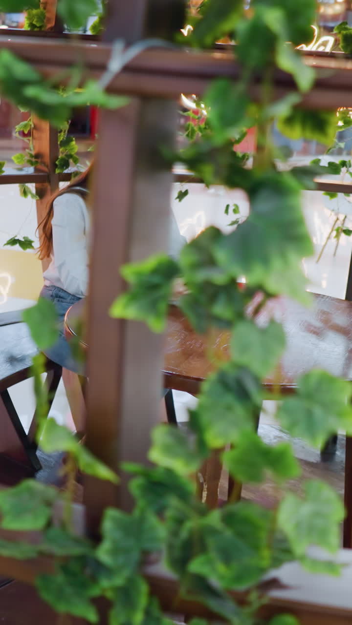 장식 된 나무 좌석에서 전화에 초점을 맞추고, 그녀의 에 쇼핑 가방, 배경에서 는 사람과 함께, 활기찬 쇼핑몰 내부의 활기찬 레스토랑 설정