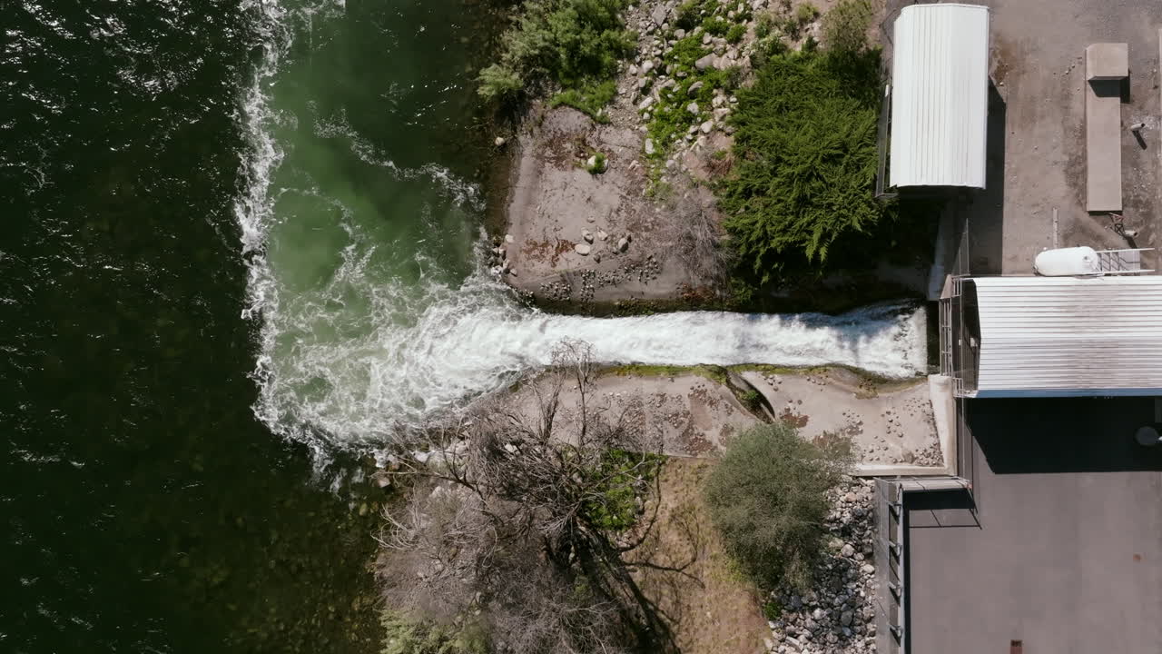 A top-down view shows a controlled stream of treated water discharging into a green-toned river from the edge of the plant