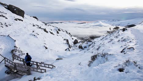 Aventurero-En-Paisaje-Nevado,-Nubes-En-El-Fondo,-España,-Tiro-Panorámico