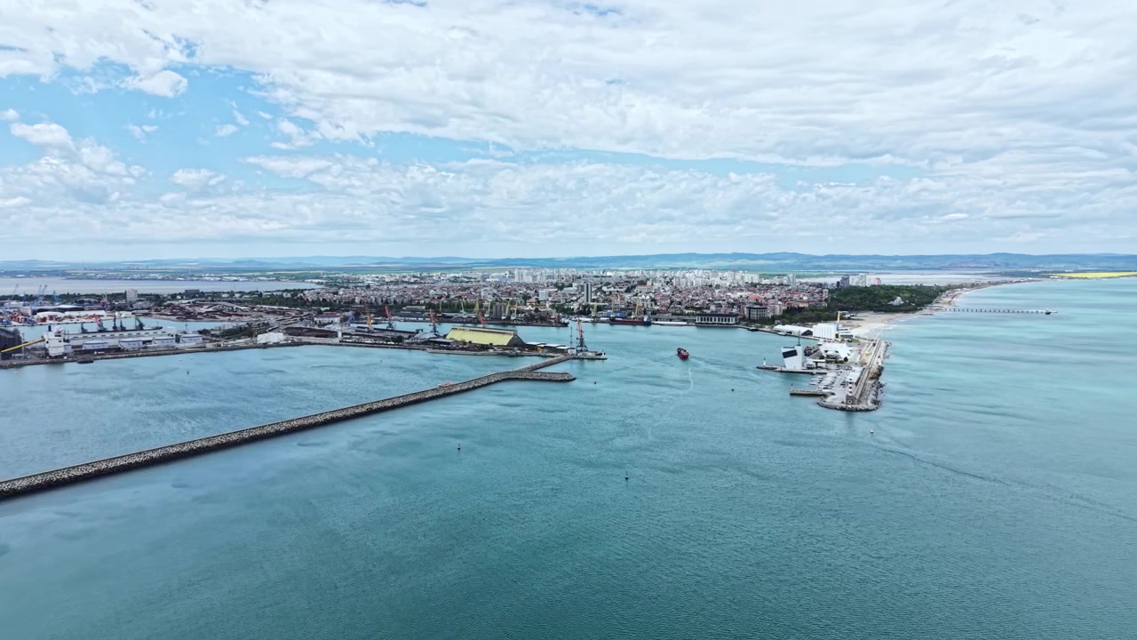Utsikt över kuststaden med hamn och båtar under blå himmel i dagsljus