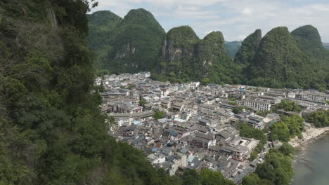 drone flying close to a karst mountain, revealing the yangshou town, in china