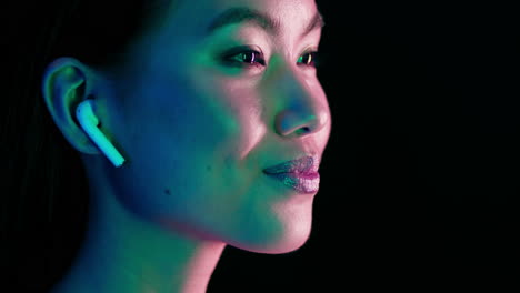 woman with earbuds in neon light