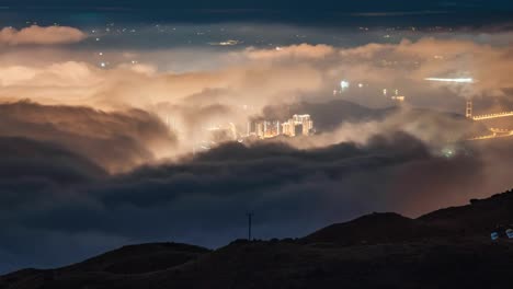 night time lapse zoom over tai mo shan, hong kong with clouds moving. beautiful night city lights of tai mo shan ,cityscapes at mountain in hong kong. time lapse clouds on the top of mountain