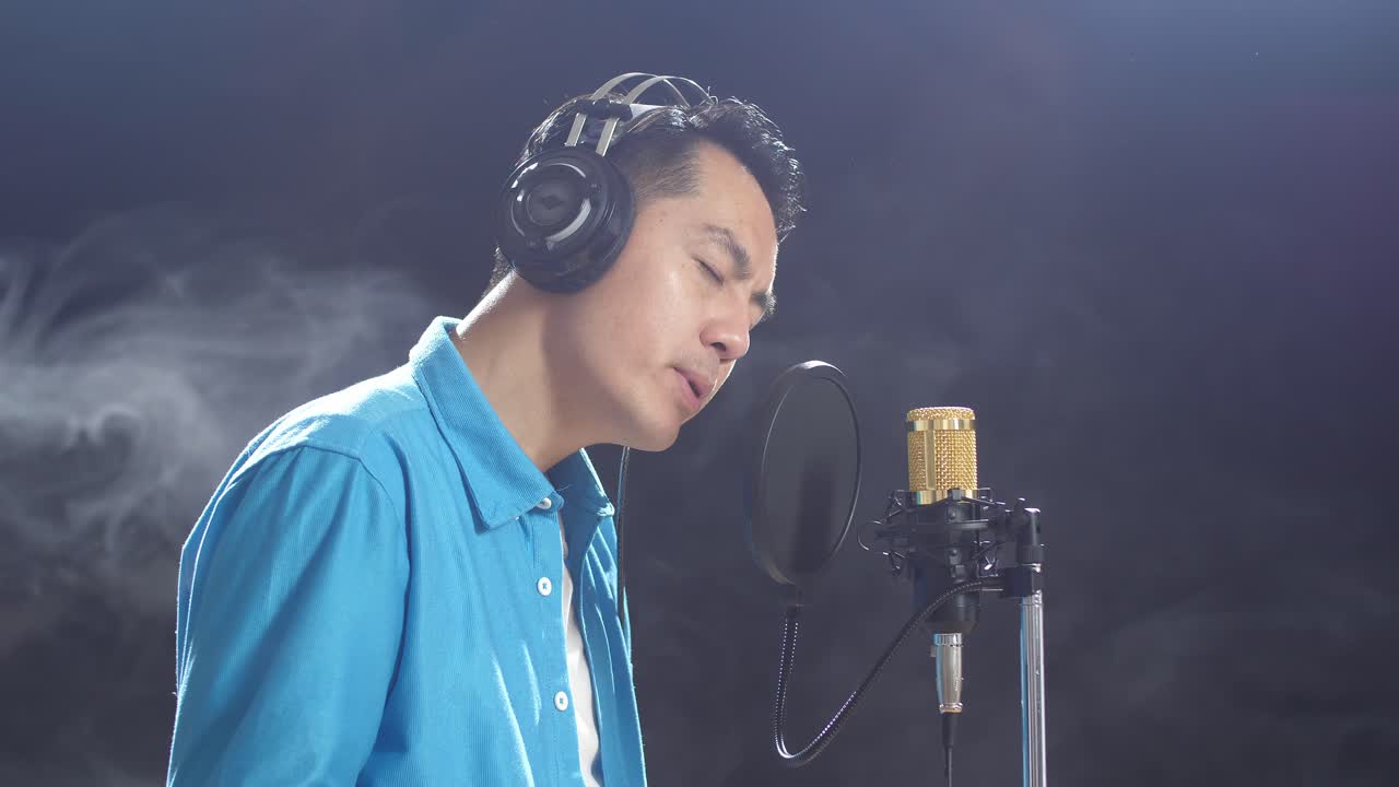 녹음 스튜디오 에서 마이크 로 노래 하는 남자