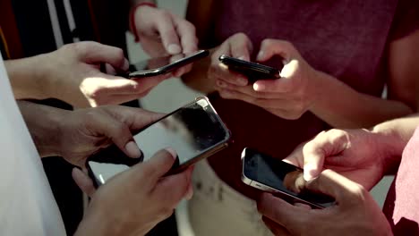 una foto recortada de jóvenes usando teléfonos inteligentes.