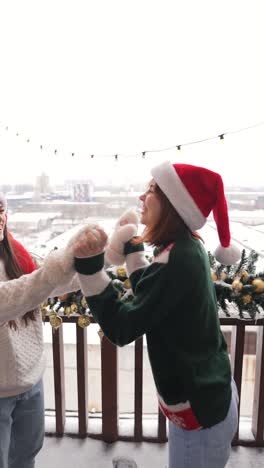 friends having fun on a snowy balcony during christmas