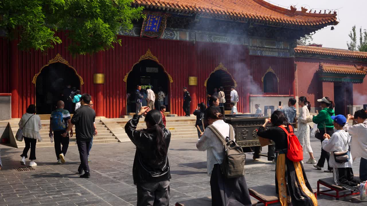Chinese people praying outside the Buddhist Lama Temple in Beijing, China