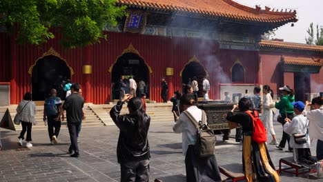chinese people praying outside the buddhist lama temple in beijing, china