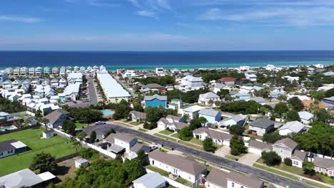 panoramic drone movement over bright suburban community with distant sandy beach, panama city beach, florida, usa