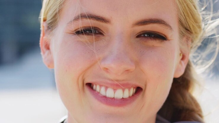 Primo piano di una giovane donna sorridente all'aperto