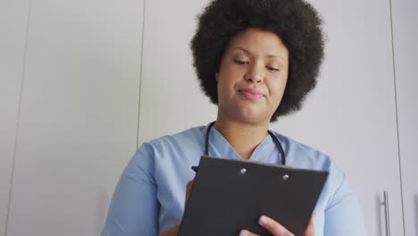 Video-of-happy-plus-size-african-american-female-doctor-using-tablet