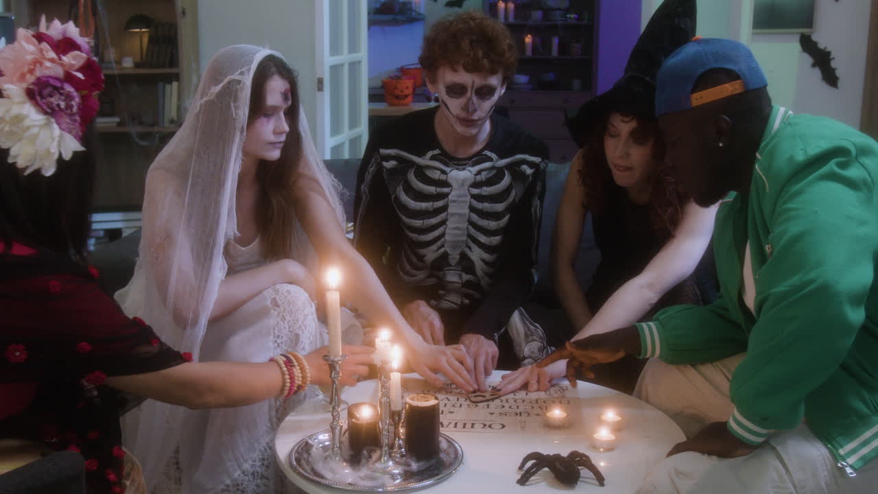 People in Halloween costumes playing with an Ouija board