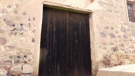 old-wooden-door-in-an-old-village-in-the-middle-of-the-desert-with-the-style-of-Arab-house