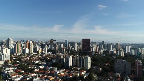 Sideways-motion-with-drone-filming-many-buildings-in-city-with-blue-sky-in-4K-resolution