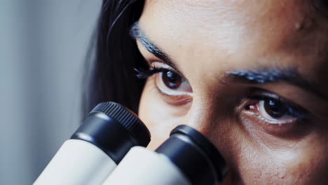 primer plano de un científico usando un microscopio