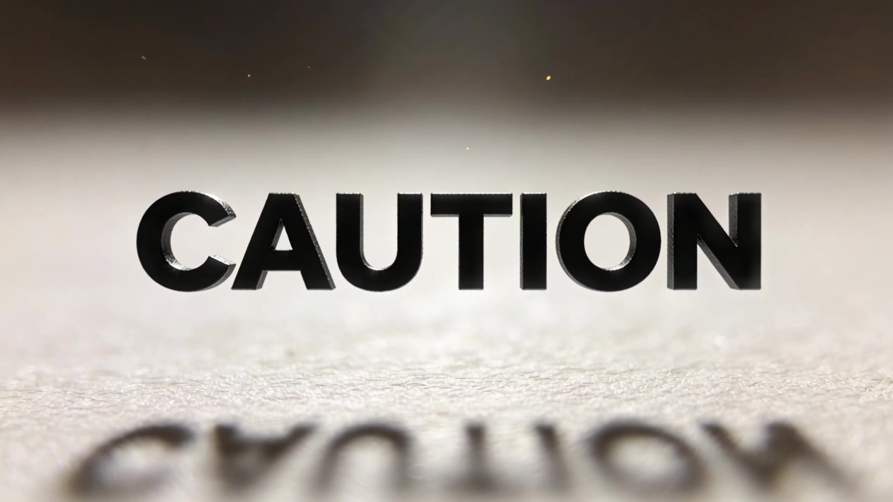 Starting clip showing CAUTION letters shifting focus as title on textured surface specks flickering