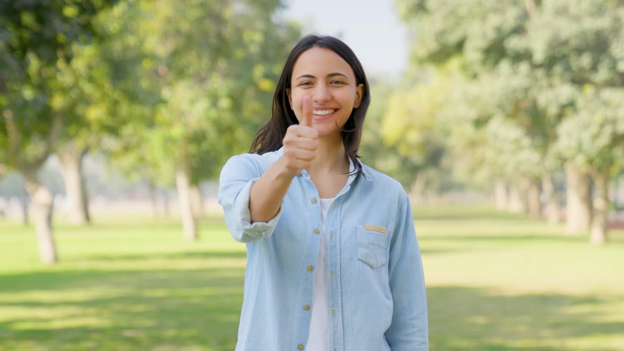 chica india mostrando los pulgares hacia arriba