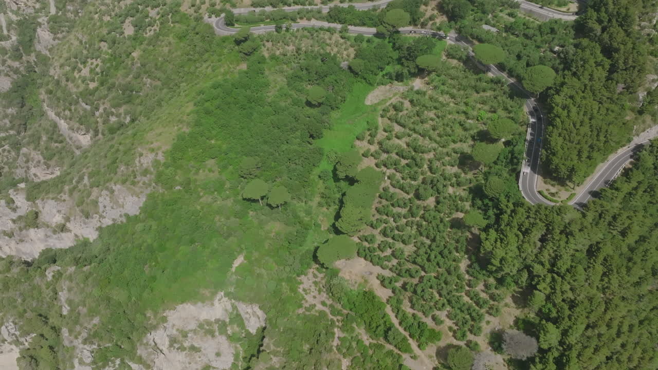 imágenes aéreas de automóviles que suben y bajan por una carretera ventosa en la costa de amalfi