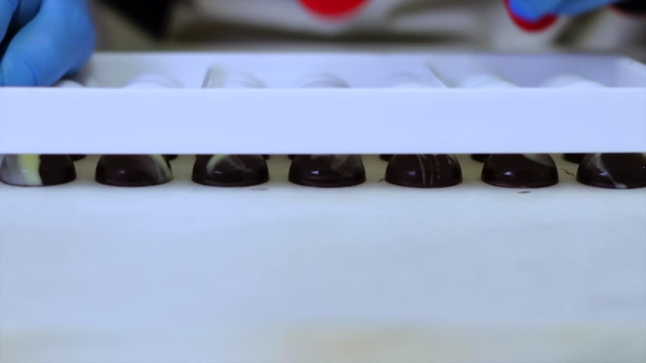 Taking chocolate candies out of the mould
