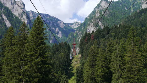 Mountain views from a cable car. Visitors enjoy breathtaking views while riding a cable car through lush green forests and towering mountains