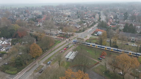 High-angle-view-of-train-driving-over-rail-road-crossing-with-traffic-waiting