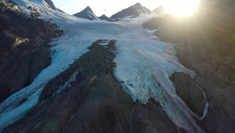 melting snow on snowcapped mountain slope under sunlight in summer alaska