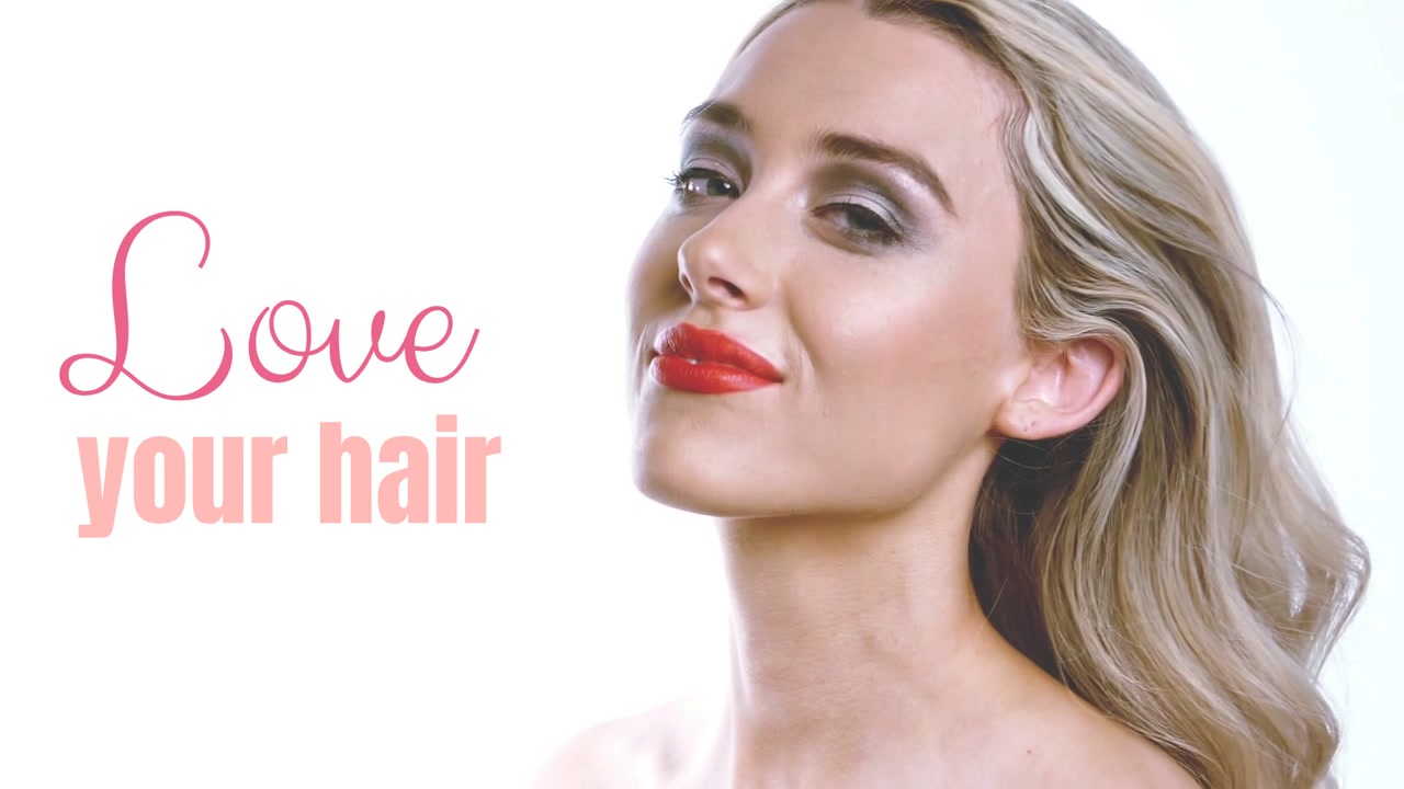 Modella che entra da destra e si scuote i capelli, oscurando la grafica "Love your hair" a sinistra, per promuovere i capelli
