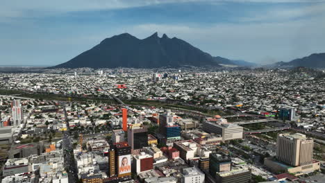 aerial view backwards over the monterrey cityscape, in sunny nuevo león, mexico