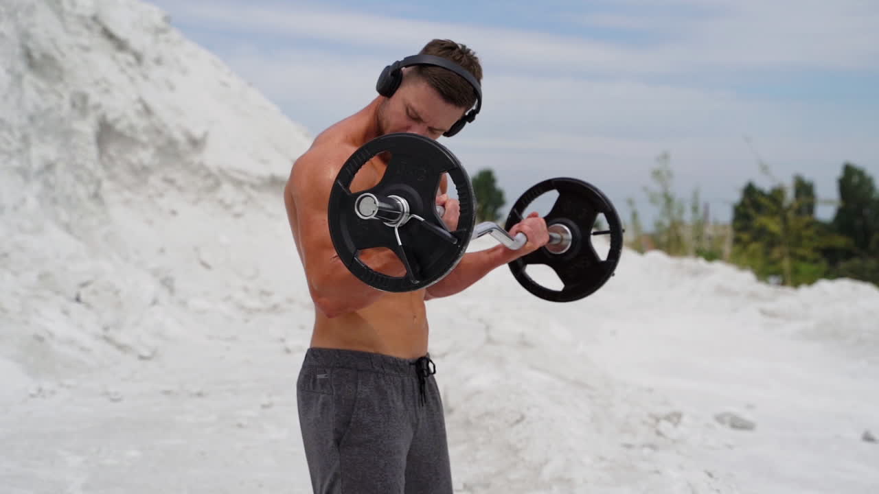 Training with music on nature. Fitness man wearing headphones and training on nature