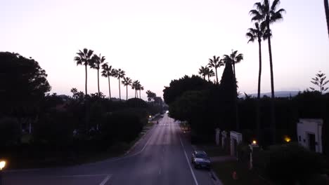 drone shot flying over residential street in evening darkness in spain