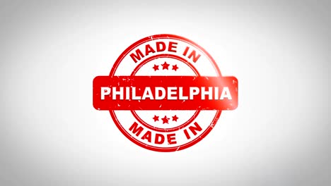 made in philadelphia signed stamping text wooden stamp animation. red ink on clean white paper surface background with green matte background included.