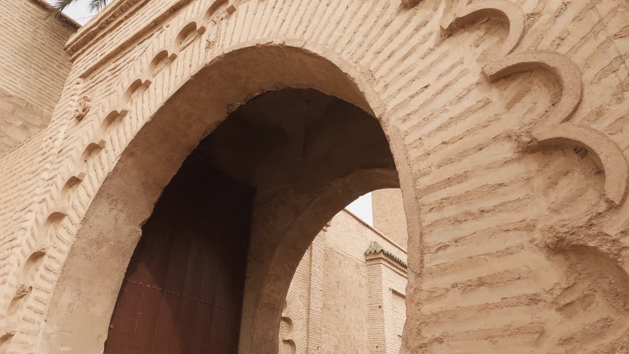Dolly walk through archway with koutoubia mosque