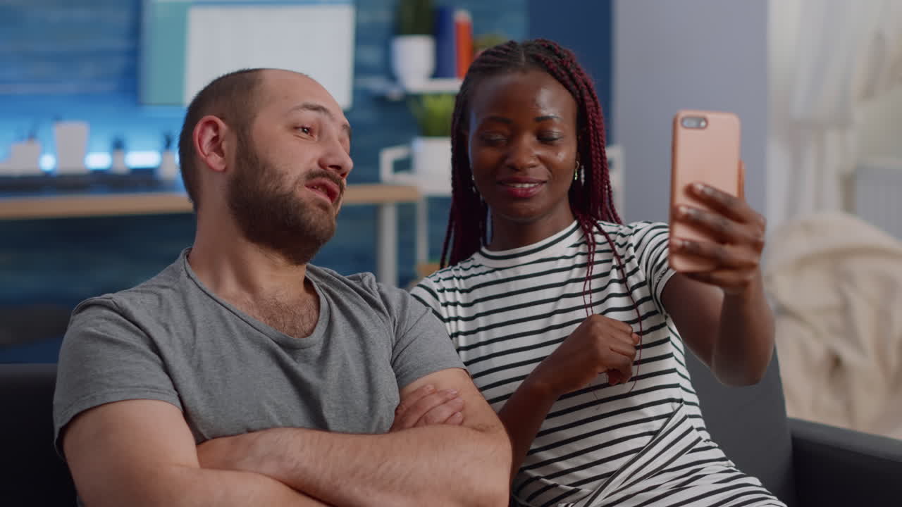 Young interracial couple using online video call conference