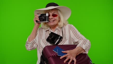 Mature-woman-photographer-traveler-in-sunglasses-taking-picture-photos-on-retro-camera,-chroma-key